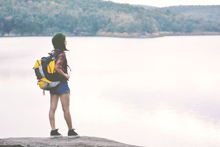 Happy Asian hipster women backpack in nature background, Relax time on holiday concept travel , color of vintage tone and soft focusの写真素材