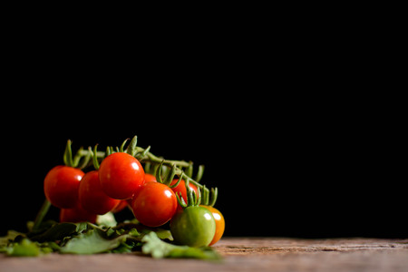 Still life group of tomato on old wood and black background, soft focusの写真素材