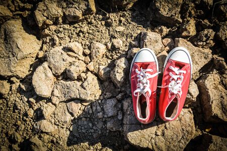 Red sneaker on crack dry ground, concept droughtの写真素材