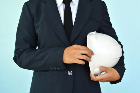 Portrait of engineer holding hat on blue background, selective and soft focusの写真素材