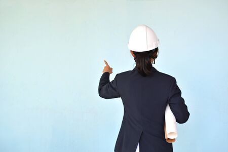 Portrait of engineer holding hat on blue background, selective and soft focusの写真素材