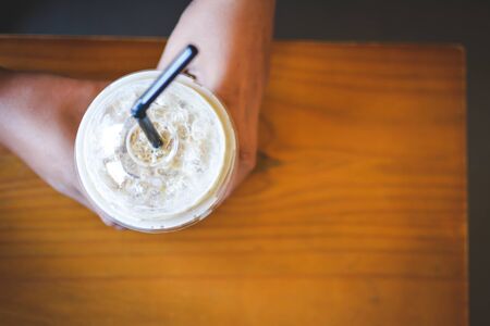 Ice coffee on a wooden table in coffee shop background hipster tone soft and selective focusの写真素材