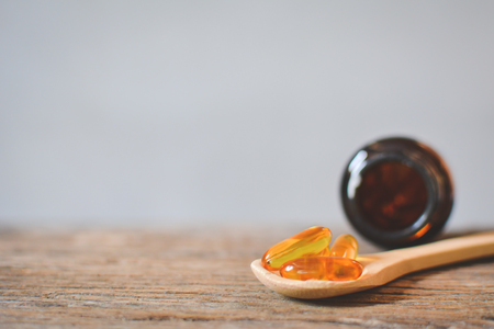 Cod liver oil on spoon wood backgroundの写真素材