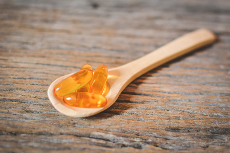 Cod liver oil on spoon wood backgroundの写真素材