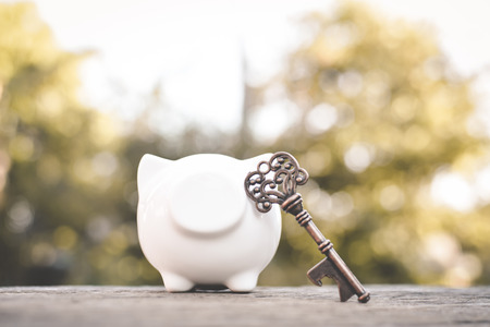 Old key piggy bank on wood a bokeh background with copy space a color of vintage tone selective and...