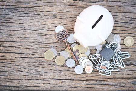 Old key  coin piggy bank on wood background with copy space a color of vintage tone selective and soft focusの写真素材