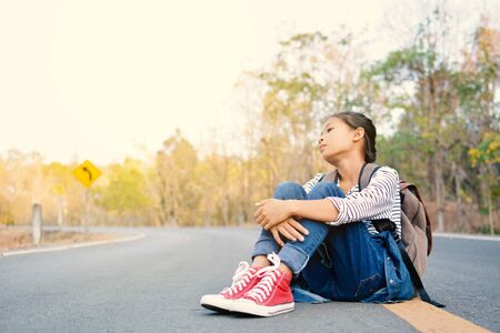 Happy Asian girl backpack  in nature background, Relax time on holiday concept travel ,color of vintage tone and soft focusの写真素材