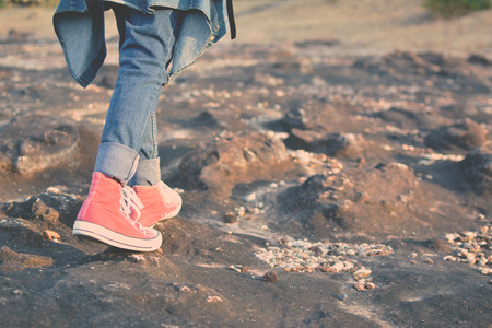 Feet red sneaker a girl in nature and relax time on holiday. selective and soft focus color of...