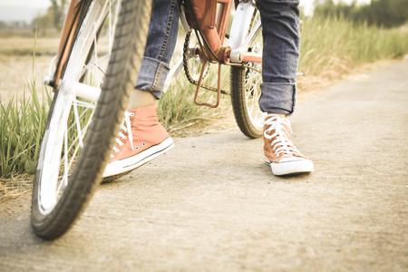 Happy girl with bicycle on grass field, selective and soft focus, concept travel in holidayの写真素材