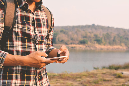 Happy Asian hipster man backpack in nature background, Relax time on holiday concept travel , color of vintage tone and soft focusの写真素材