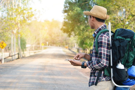 Happy Asian hipster man backpack in nature background, Relax time on holiday concept travel , color of vintage tone and soft focusの写真素材