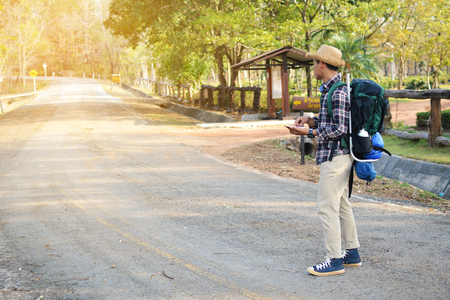 Happy Asian hipster man backpack in nature background, Relax time on holiday concept travel , color of vintage tone and soft focusの写真素材