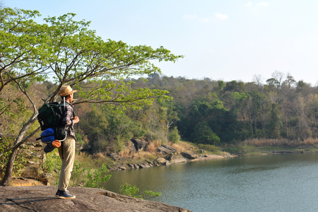 Happy Asian hipster man backpack in nature background, Relax time on holiday concept travel , color of vintage tone and soft focusの写真素材