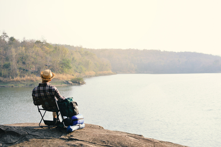 Happy Asian hipster man backpack in nature background, Relax time on holiday concept travel , color of vintage tone and soft focusの写真素材