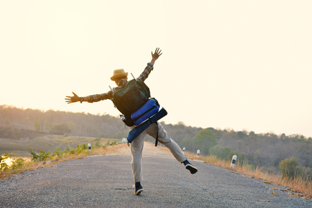 Happy Asian hipster man backpack in nature background, Relax time on holiday concept travel , color of vintage tone and soft focusの写真素材