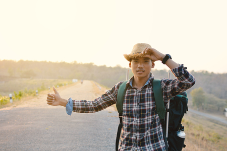 Happy Asian hipster man backpack in nature background, Relax time on holiday concept travel , color of vintage tone and soft focusの写真素材