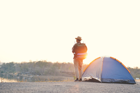 Happy Asian hipster man backpack in nature background, Relax time on holiday concept travel , color of vintage tone and soft focusの写真素材