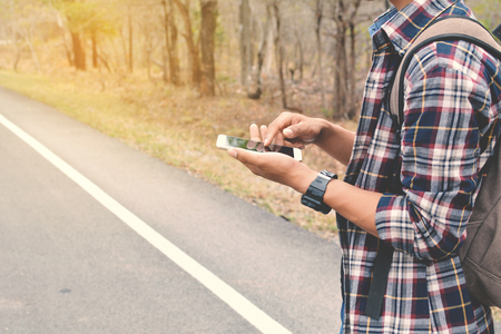 Happy Asian hipster man backpack in nature. Relax time on holiday concept travel , color of vintage tone and soft focusの写真素材
