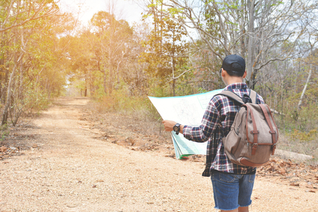 Happy Asian hipster man backpack in nature. Relax time on holiday concept travel , color of vintage tone and soft focusの写真素材