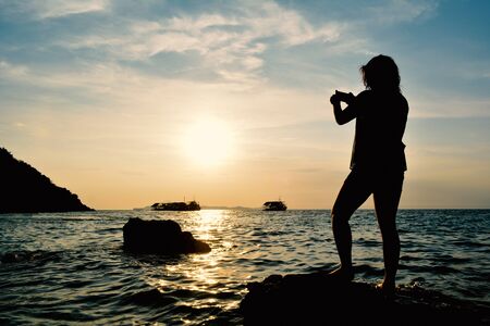 Silhouette of women relaxing on the sea concept travel in summerの写真素材