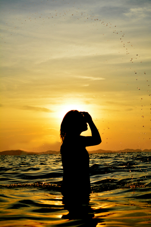 Silhouette of women relaxing on the sea concept travel in summer timeの写真素材