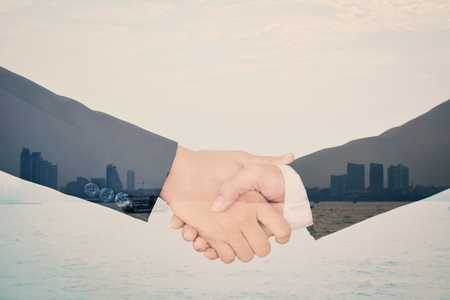Double exposure of business shake hand in building background, selective of focusの写真素材