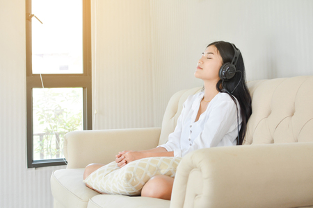 Beautiful young women listening a song in the room at home relax time on holidayの写真素材