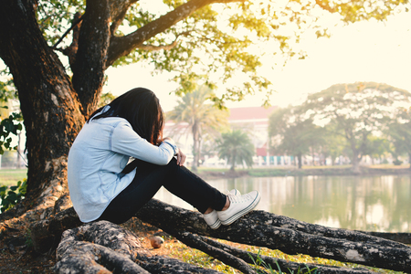 Beautiful women sad and crying in the park, vintage tone and selective focusの写真素材