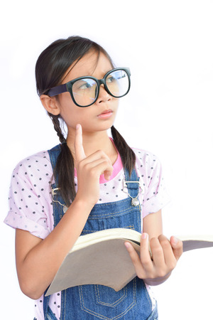 Portrait of little Asian girl reading a book on white backgroundの写真素材