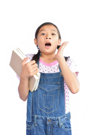 Portrait of little Asian girl holding a book on white backgroundの写真素材