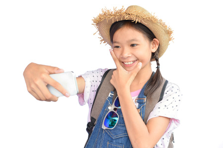 Portrait of little Asian girl holding smartphone on white background, concept travelの写真素材