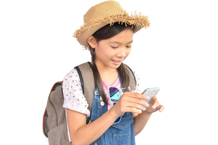 Portrait of little Asian girl holding smartphone on white background, concept travelの写真素材