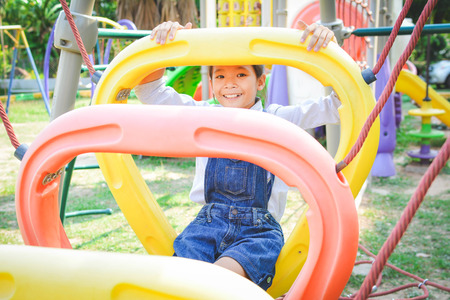 Asian girl playing in playground happy on holiday selective and soft focusの写真素材