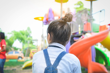 Asian girl playing in playground happy on holiday selective and soft focusの写真素材