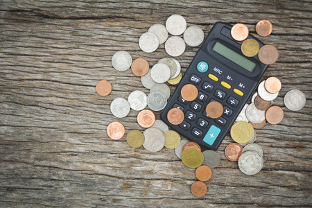 Close up calculator and coin on wood backgroundの写真素材