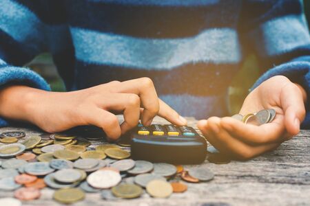 Hands girl holding calculator and coin selective and soft focus hipster toneの写真素材