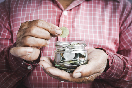 Old hands holding coins selective and soft focus vintage toneの写真素材