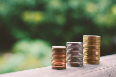 Close up  coin on wood and tree bokeh background selective and soft focus hipster tone