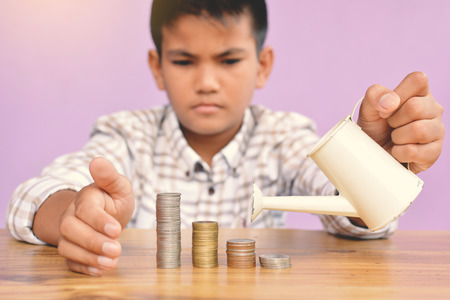Hands boy watering coin selective and soft focus hipster toneの写真素材