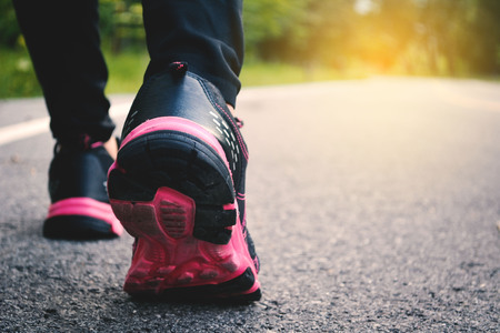 Feet women running on the road for health,vintage tone selective focus of shoeの写真素材