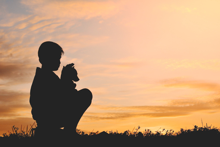 Silhouette boy playing with little dog on the sky sunset color of vintage toneの写真素材