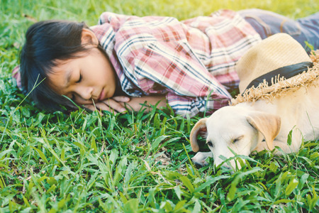 Happy girl playing with little dog in nature background, travel on holiday color of vintage tone and soft focusの写真素材