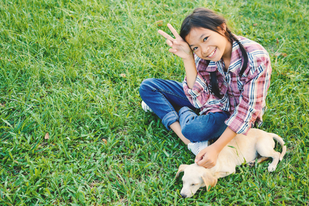 Happy girl playing with little dog in nature background, travel on holiday color of vintage tone and soft focusの写真素材