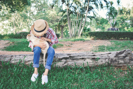 Happy girl playing with little dog in nature background, travel on holiday color of vintage tone and soft focusの写真素材