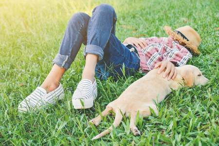 Happy girl playing with little dog in nature background, travel on holiday color of vintage tone and soft focusの写真素材