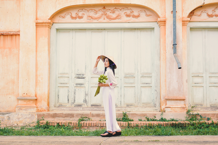 Beautiful women Vietnam with white ao dai dress in old city , selective and soft focus of face color vintage styleの写真素材