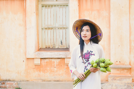 Beautiful women Vietnam with white ao dai dress in old city , selective and soft focus of face color vintage styleの写真素材