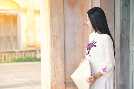 Beautiful women Vietnam with white ao dai dress in old city , selective and soft focus of face color vintage styleの写真素材
