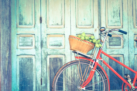 Hipster red bicycle in old building walls backgroundの写真素材