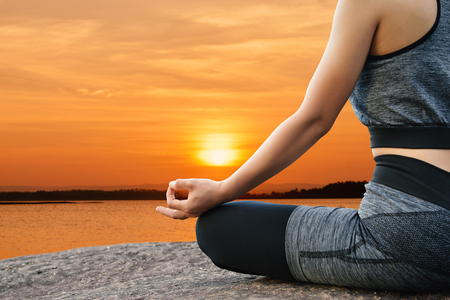 Beautiful women yoga in nature sunset background, hipster tone and selective focusの写真素材